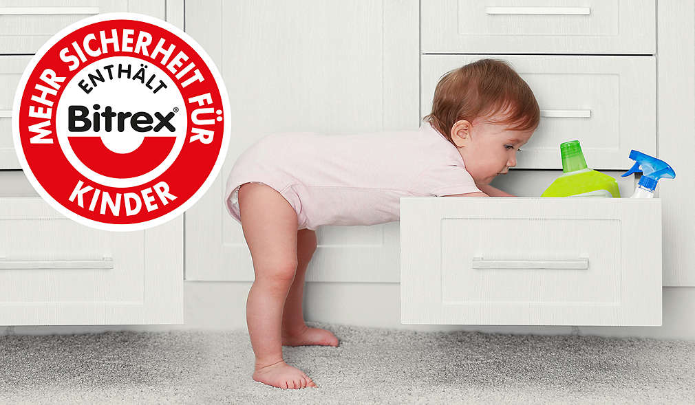 Kleinkind kramt in Schublade mit Reinigungsmitteln