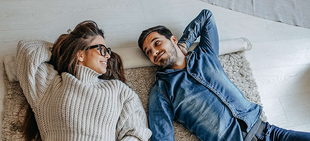 Mann und Frau auf der Sofa umarmen sich