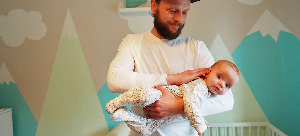 Vater nimmt Baby in den Fliegergriff