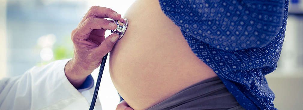 Stethoskop am Bauch einer Schwangeren