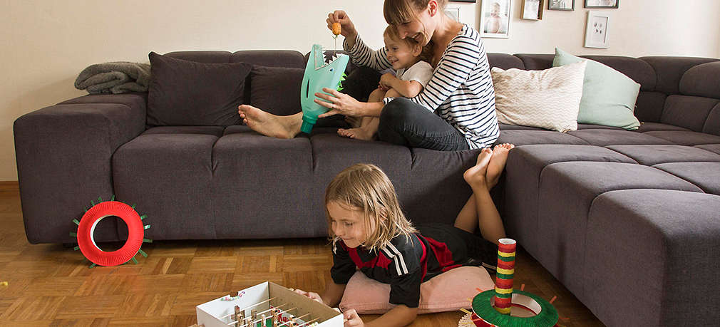 Mutter und Kinder spielen im Wohnzimmer