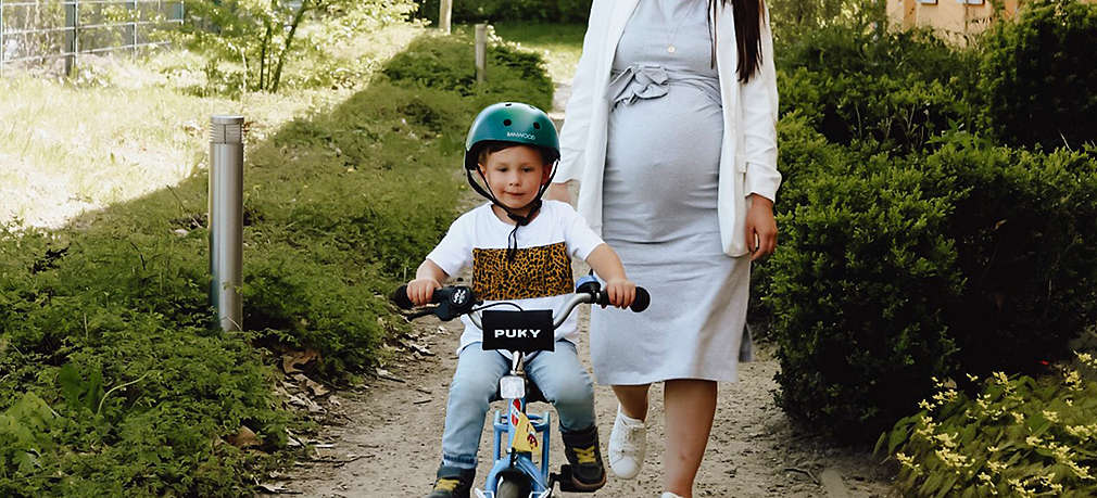 Mutter begleitet ihr Kind beim Fahrradfahren