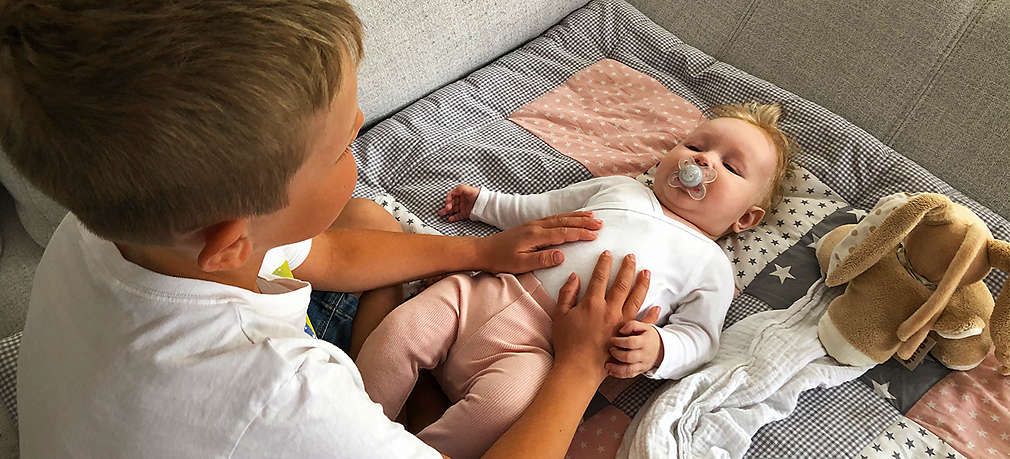 Großer Bruder mit kleinem Geschwisterkind auf Couch