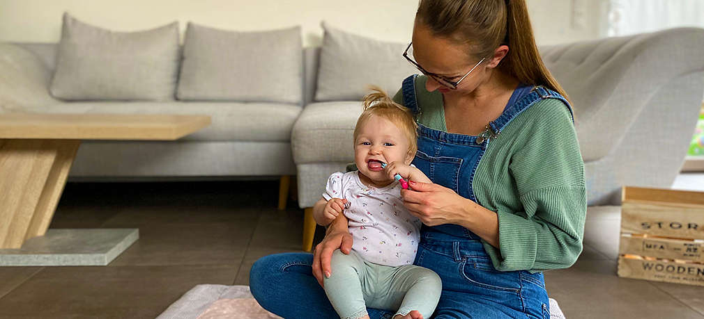 Baby sitzt bei der Mutter auf dem Schoß