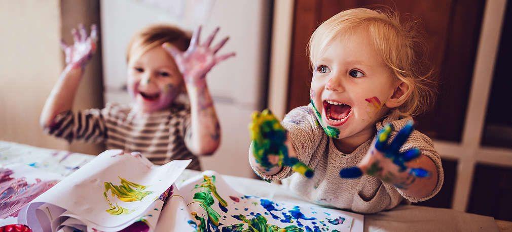 Zwei Kinder malen mit Fingerfarben