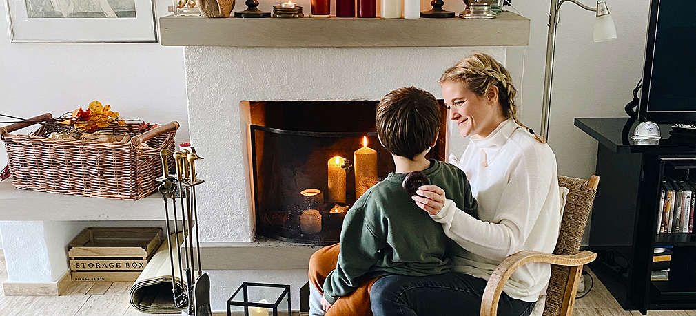 Mutter und Kind sitzen vor dem Kamin