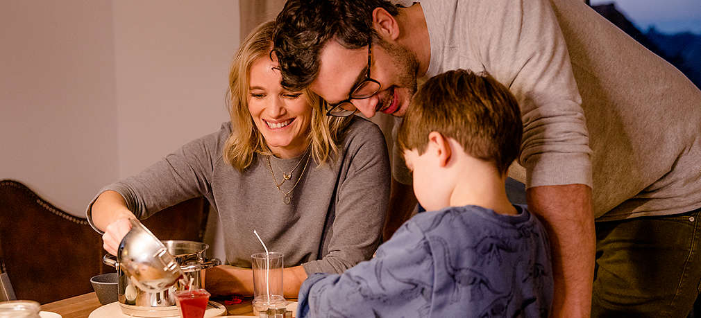 Mutter, Vater und Kind gießen Kerzen