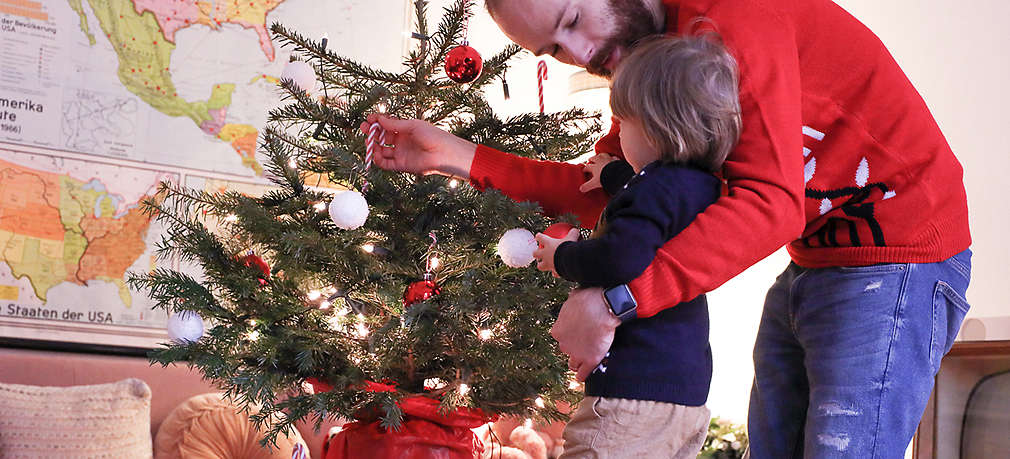 Vater und Sohn schmücken den Weihnachtsbaum