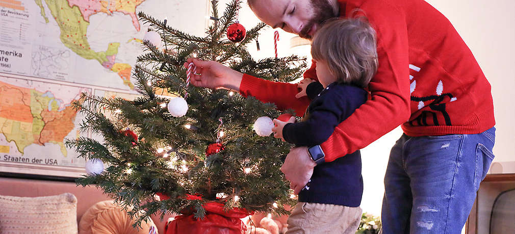 Vater und Sohn schmücken den Weihnachtsbaum