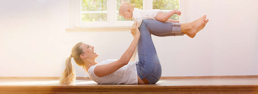 Junge Mutter mit Baby bei der Rückbildungsgymnastik