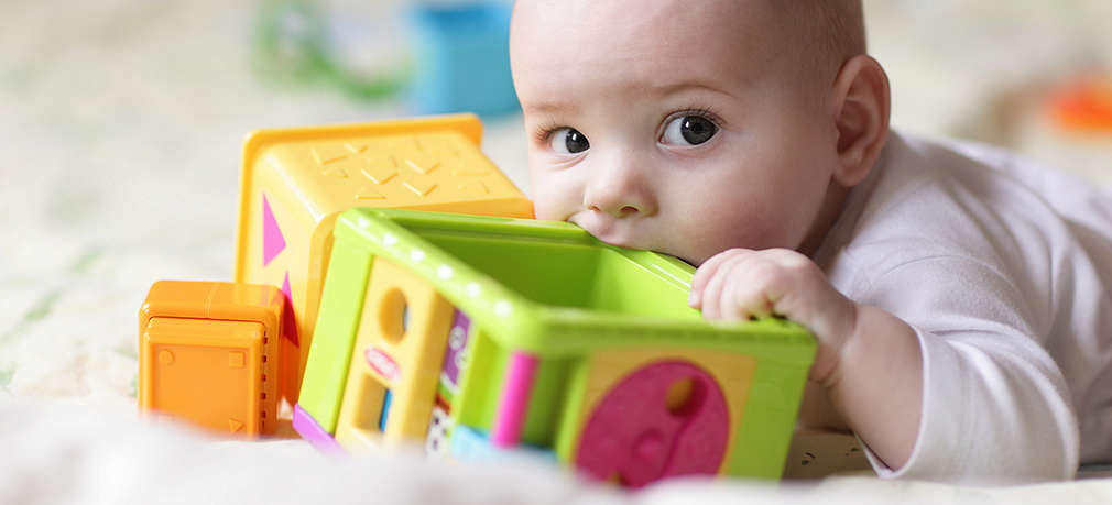 Baby nuckelt an Spielzeug