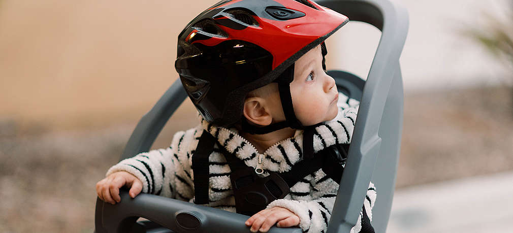 Baby mit Fahrradhelm im Kindersitz