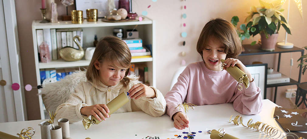 Zwei Kinder sitzen am Tisch und basteln