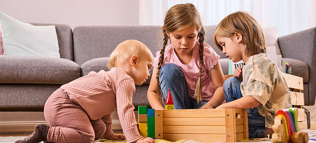 Drei Kinder spielen im Wohnzimmer