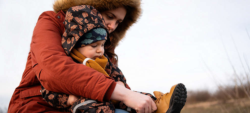 Frau zieht Baby Schuhe an