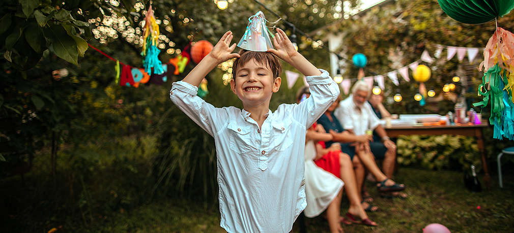 Junge im Garten mit Partyhut