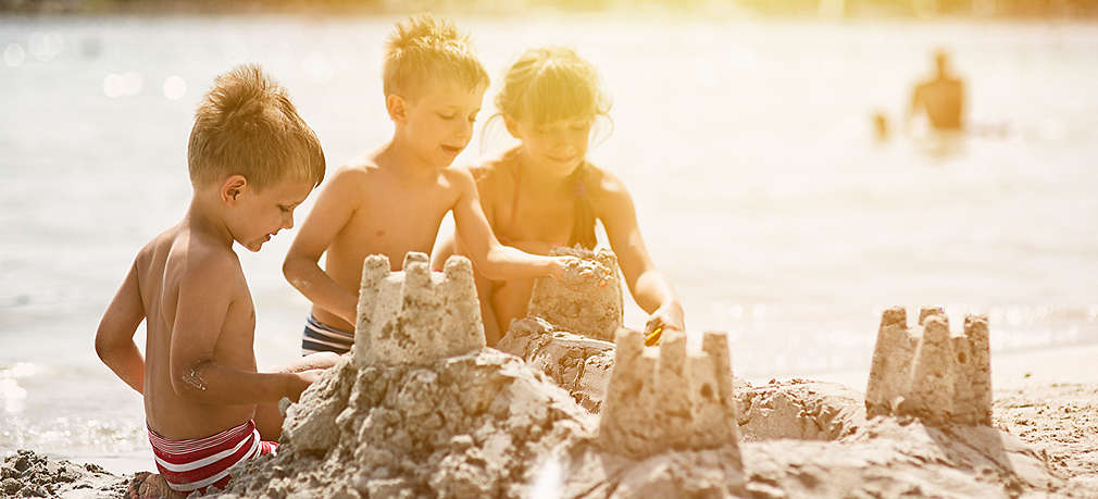 Kinder bauen eine Sandburg