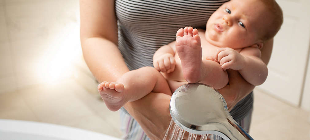 Baby beim Abhalten im Arm seiner Mutter