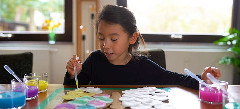 Mädchen färbt Pads mit Wasserfarben ein