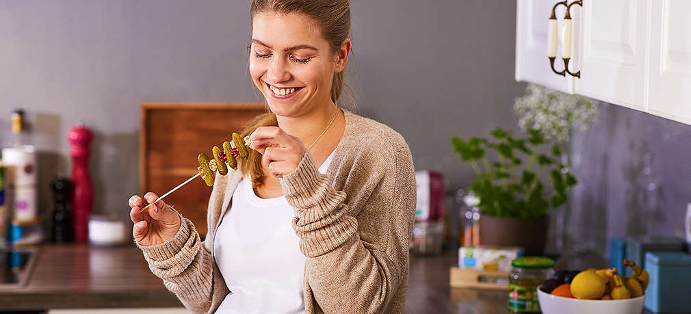 Schwangere Frau isst Gurken