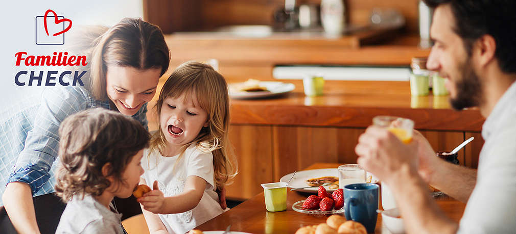 Vierköpfige Familie am Frühstückstisch