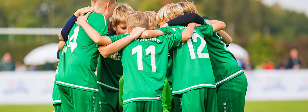 U11-Fußballmannschaft jubelt und umarmt sich