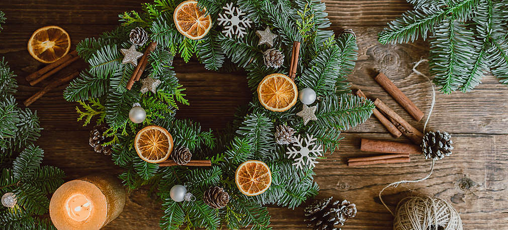 Ein selbst gemachter Adventskranz mit Orangenscheiben und Zimtstangen dekoriert
