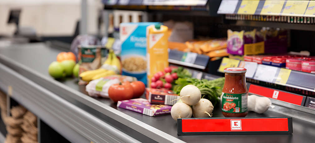 Zu sehen ist ein Kassenband in einer Kaufland-Filiale, auf dem viele Einkäufe liegen