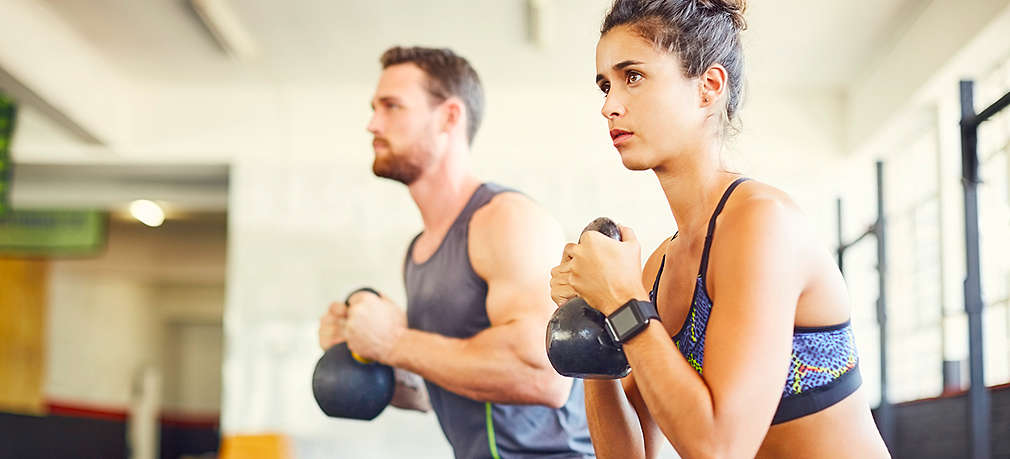 Mann und Frau halten Gewichte im Fitnesstudio