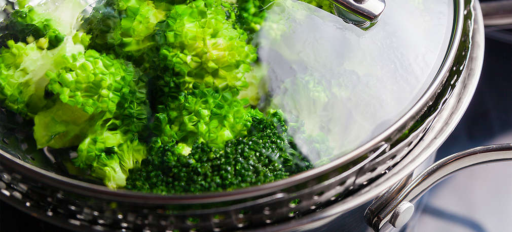 Gemüse und Salat werden in einem Kochtopf gedünstet