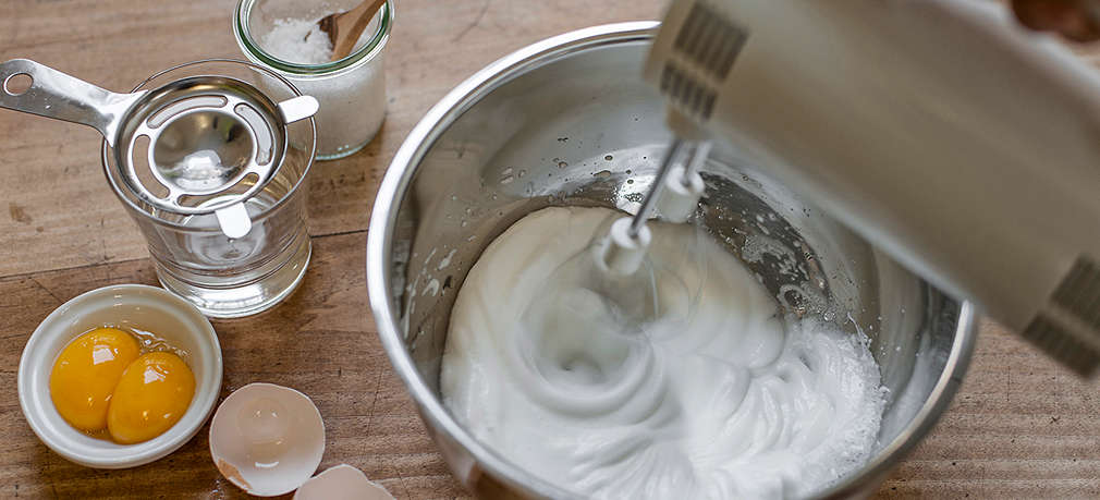 Eischnee wird im Topf mit einer Küchenmaschine geschlagen