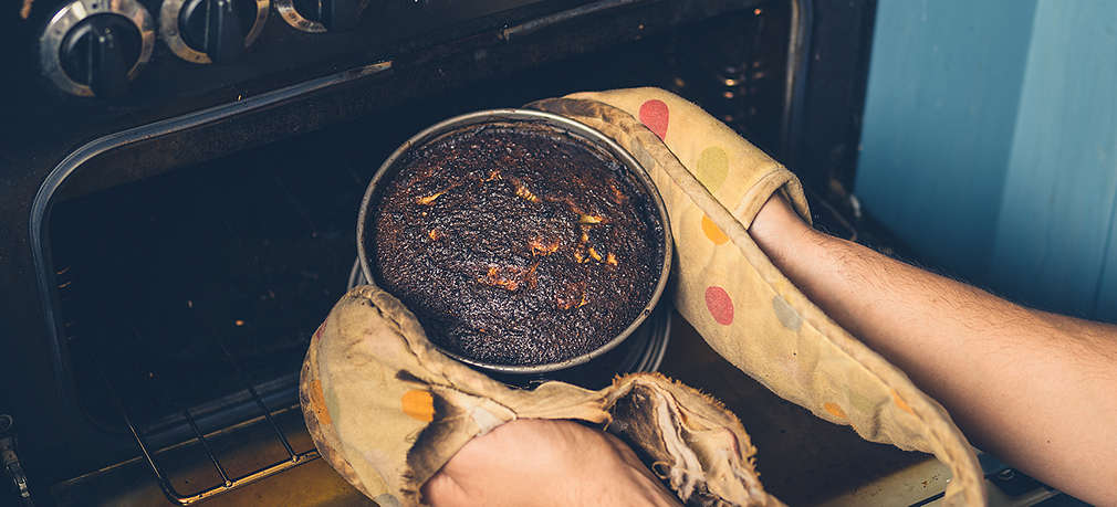 Verbrannter Kuchen wird aus dem Ofen geholt