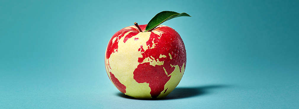 Apfel mit Blatt, auf dessen Oberfläche die Weltkarte abgebildet ist