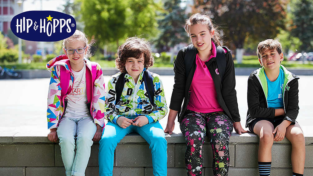Kids of different ages sitting on a bench. Hip & Hopps® logo