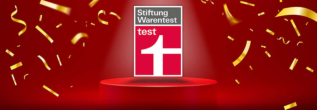 Roter Hintergrund, Podest, goldenes Konfetti, Logo: Stiftung Warentest