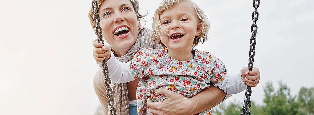 Изображение на майка, която люлее малката си дъщеричка на люлка