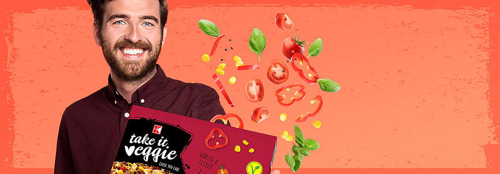 Junger Mann mit K-TAKE IT VEGGIE Pizza in der Hand