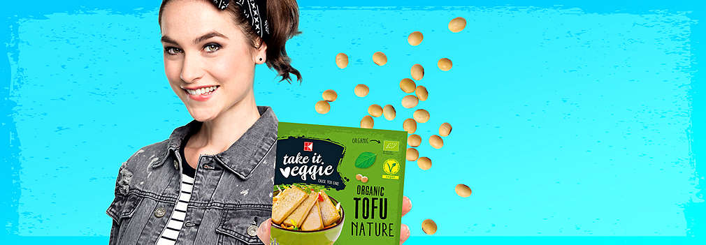 Mladá dívka drží v ruce K-take it veggie 