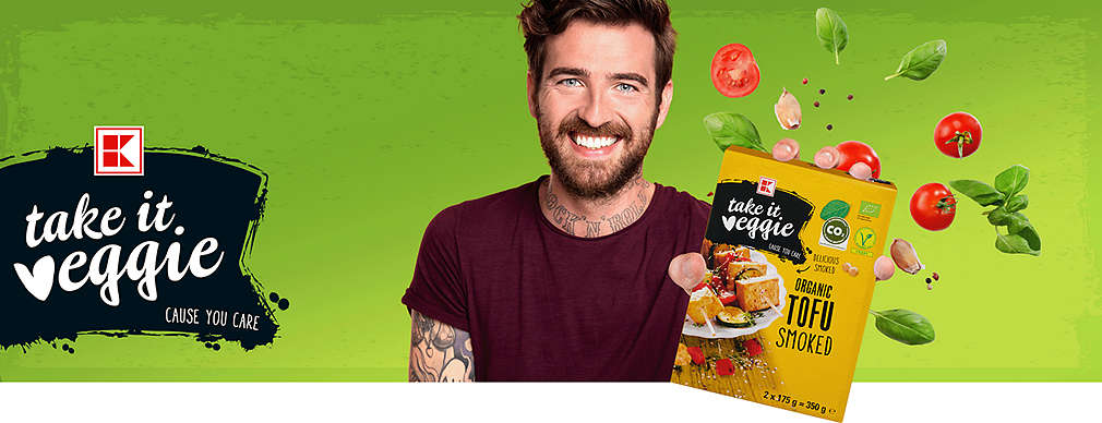 Junger Mann mit einem K-take it veggie Produkt in der Hand