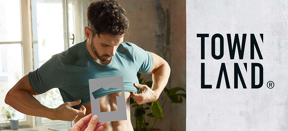 Mann zieht ein T-Shirt an, davor eine Schaplone mit T-Shirt-Ausschnitt; Logo: Townland®