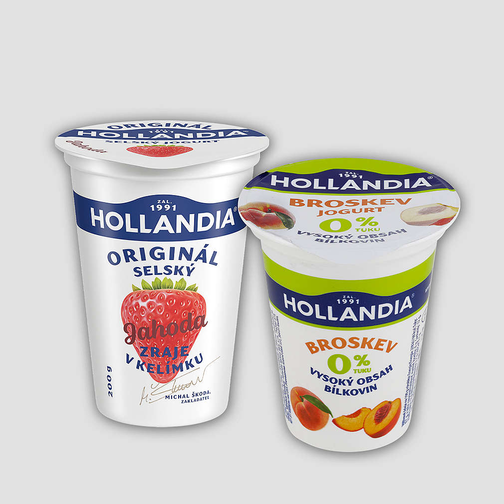 Sleva 30 % za 1 bod na různé druhy jogurtů značky Hollandia v gramáži 150 - 200 g, na obrázku znázorněn jahodový a broskvový jogurt s šedým pozadím