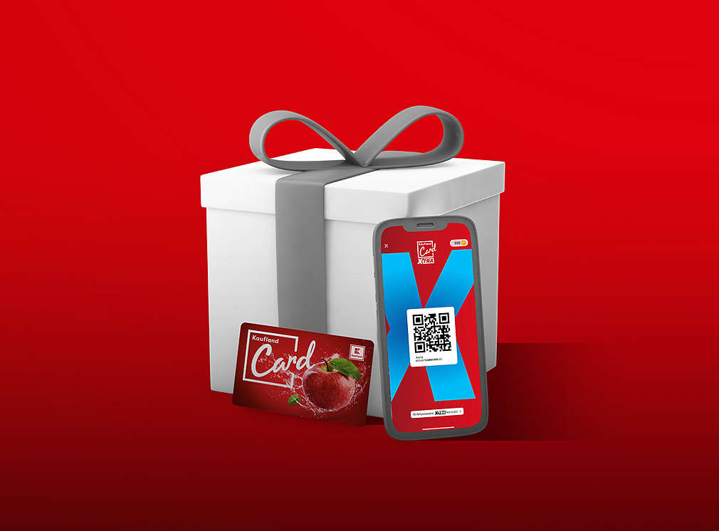 prezent ze stojącą przed nim karta Kaufland Card XTRA i telefonem