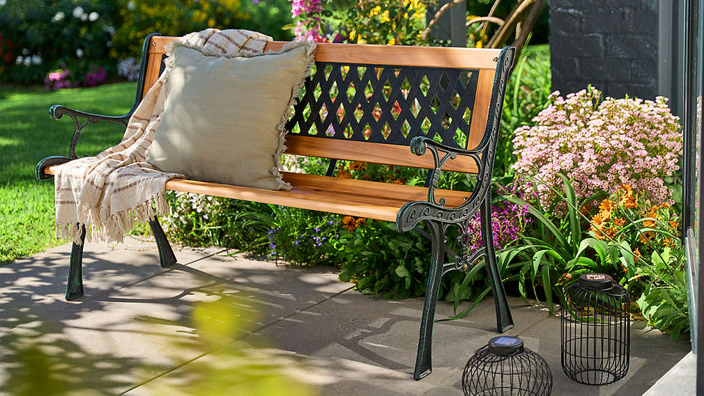 Eine einladende Gartendekoration von LIVARNO, bestehend aus einer klassischen Sitzbank, gemütlichen Textilien und dekorativen Solarlaternen., Eine einladende Gartendekoration von LIVARNO, bestehend aus einer klassischen Sitzbank, gem�tlichen Textilien und dekorativen Solarlaternen.