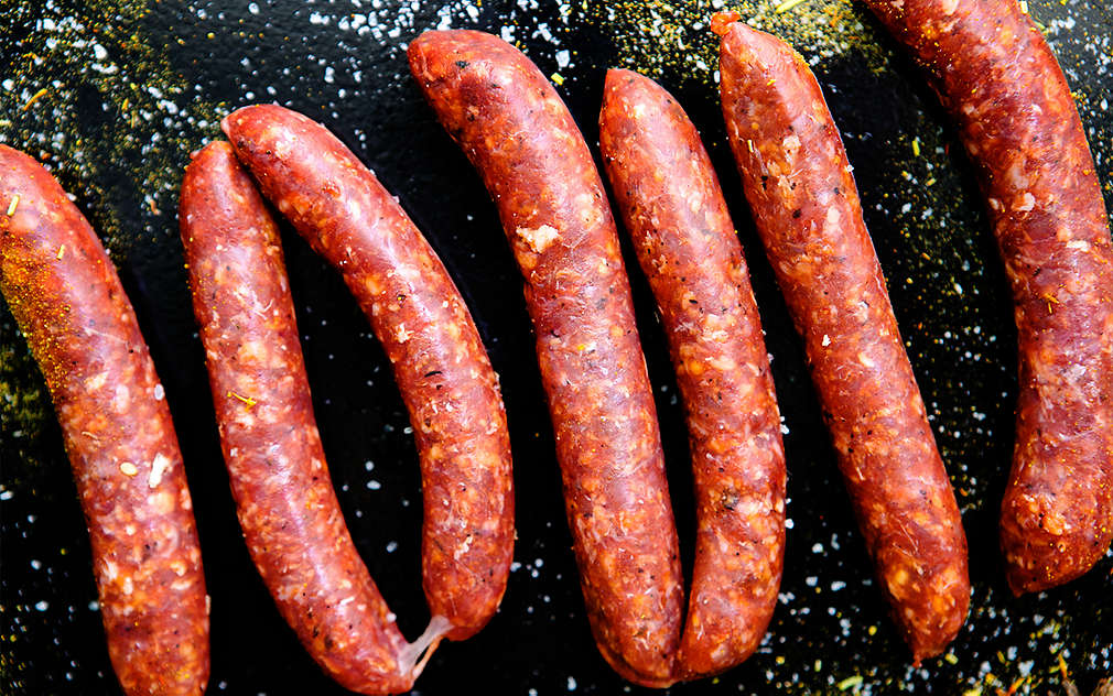 Merguez ispečen na roštilju i serviran na dasci za serviranje od škriljevca