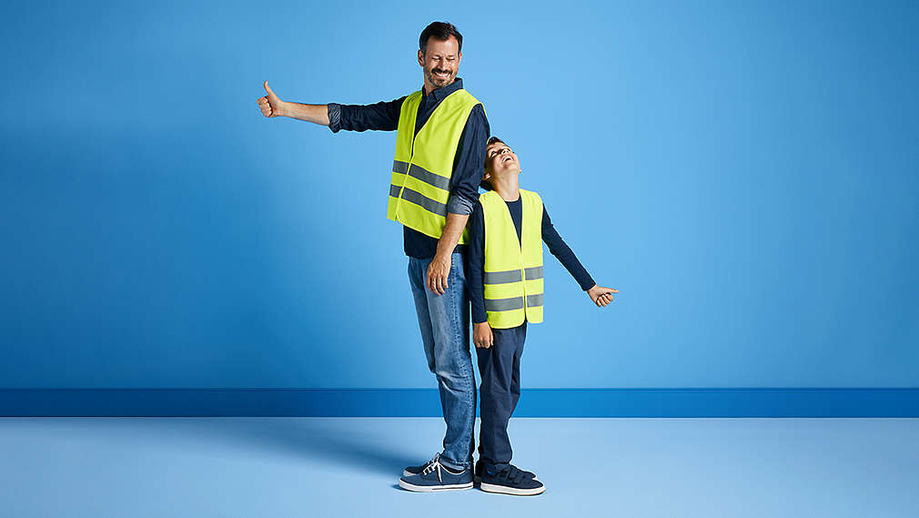 Muž a malý chlapec mají na sobě výstražné vesty značky MyProject.