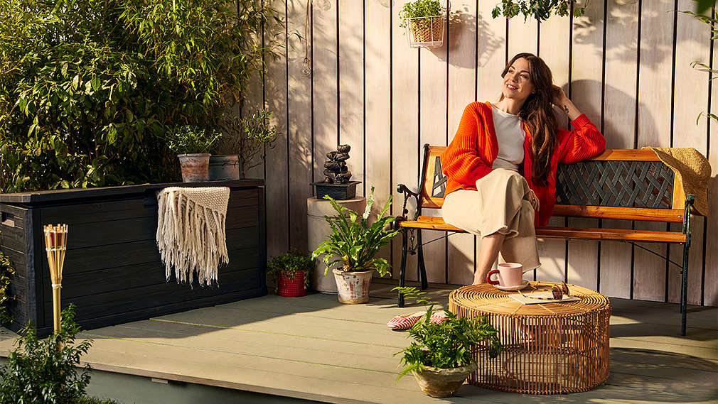 Frau deckt einen Gartentisch; Logo: COUNTRYSIDE® 