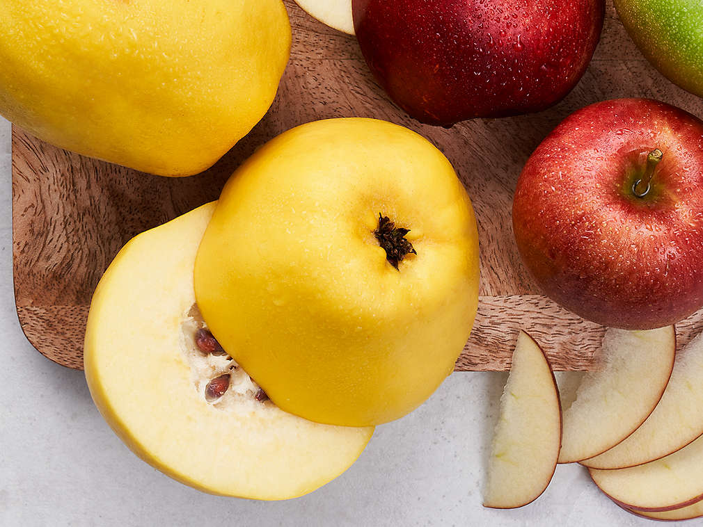 Różne owoce ziarnkowe na drewnianej desce do krojenia