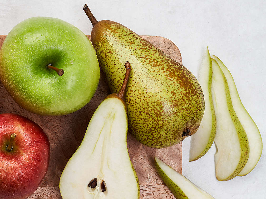 Różne świeże owoce ziarnkowe na drewnianej desce do krojenia