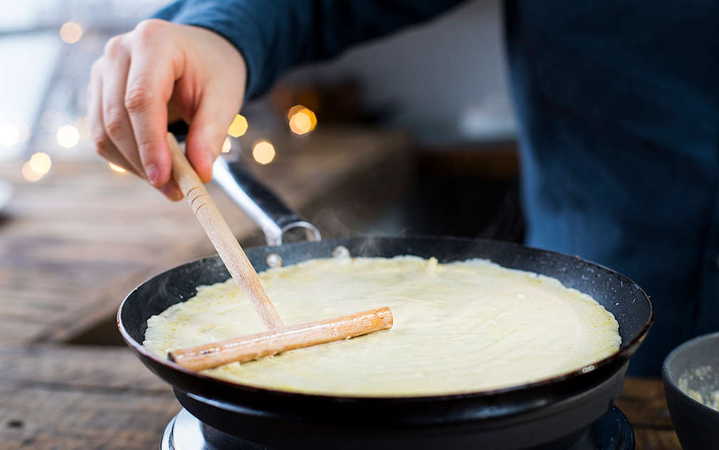 Tijesto za palačinke tanko rasporedi u posudu od lijevanog željeza s pomoću lopatice za tijesto.