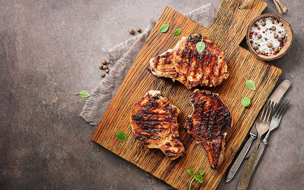 Три парчета месо върху дървена кухненска дъска